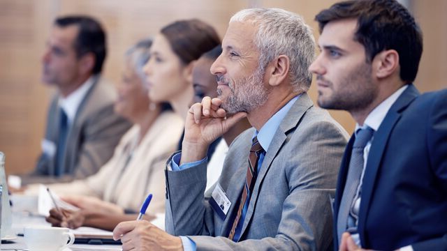En gruppe forretningsmenn samlet på konferanse.